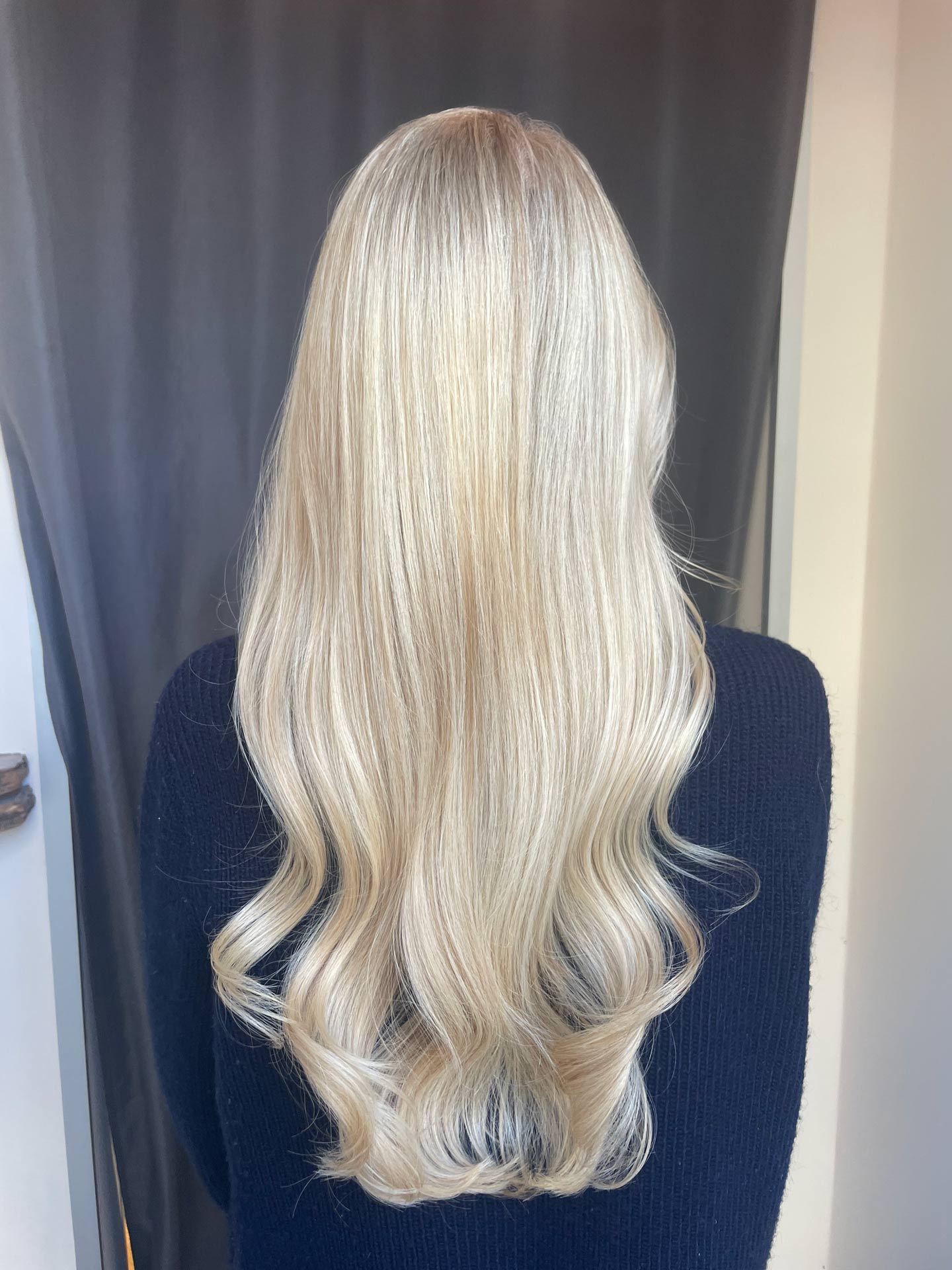 Eine blonde Balayagefärbung vor einem dunklen Hintergund